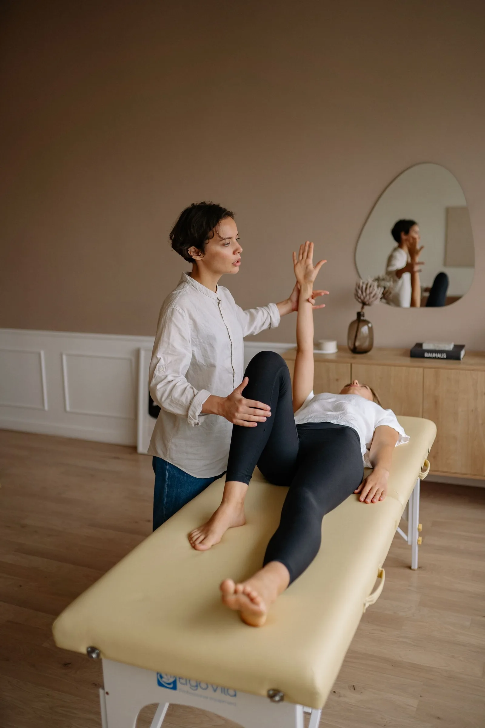 Fisioterapeuta realizando avaliação postural em paciente em ambiente clínico